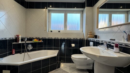 Badezimmer mit Badewanne und Dusche
