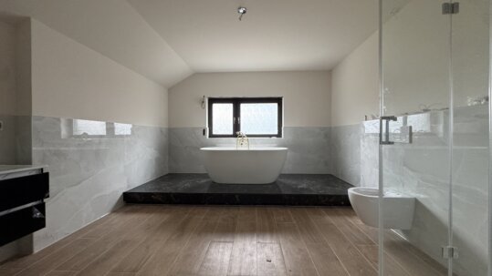 Großzügiges Badezimmer mit freistehender Badewanne und separater Dusche