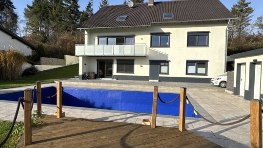 Hausansicht mit Poollandschaft